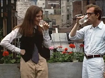 annie hall ivy autumn scene with two people drinking on a city balcony