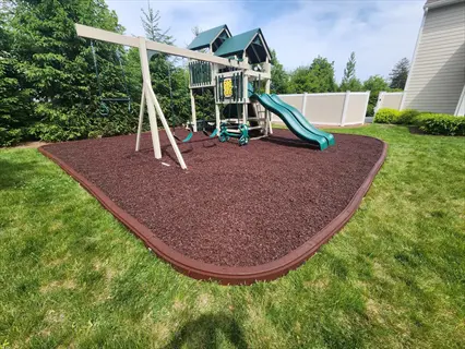 backyard rubber mulch playground with swings, slide, and playset
