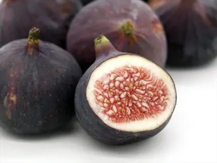 fresh ripe figs, including one sliced open to show red pulp and seeds