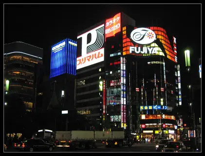 ginza lights with bright storefront signs and traffic at night