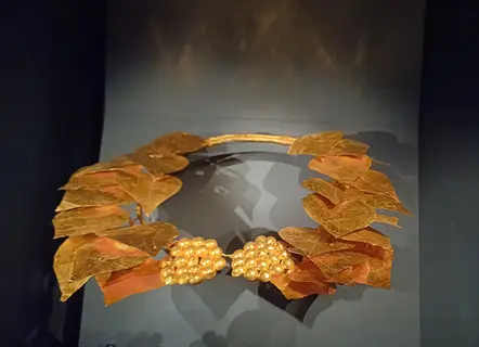 gold heart ivy wreath with amber leaves and pearl clusters on a display stand